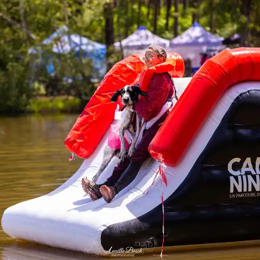 Participante de la CANI NINJA et son chien sur le toboggan gonflable du lac